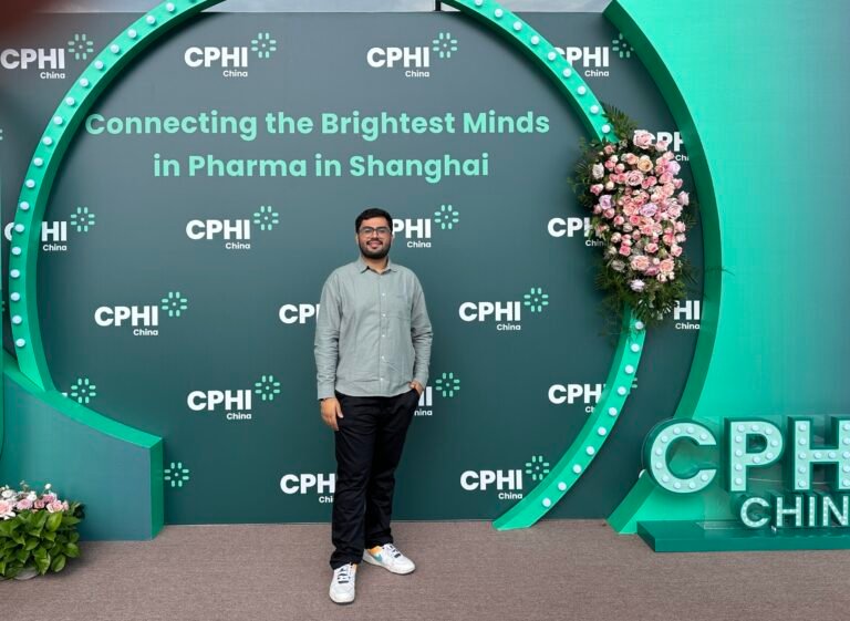 Kenil Dobariya standing in front of CPHI board